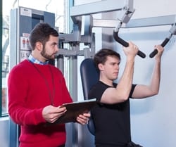 A woman looking at her watch, holding a clipboard.