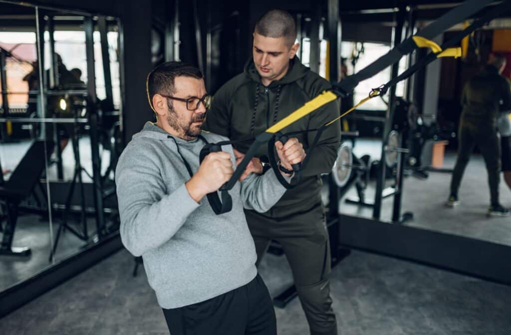 A personal trainer providing one on one guidance to a client, ensuring safe and effective movement.